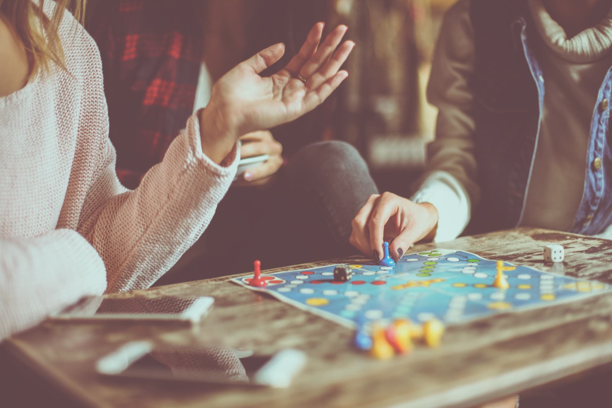 Hands playing a board game together