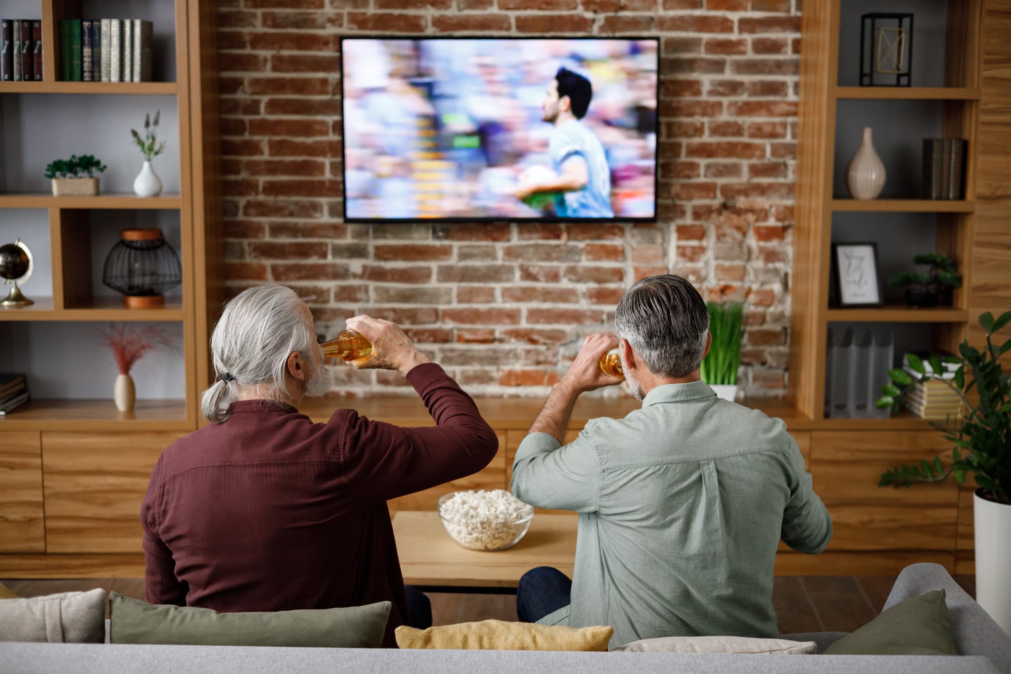 Two older men enjoying sports together at home
